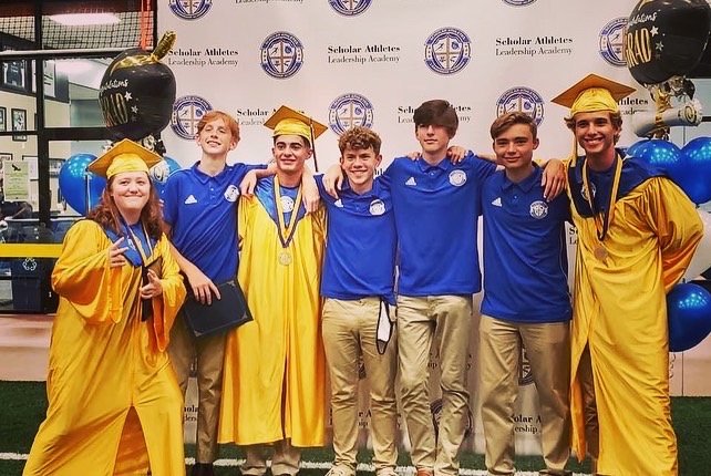 A group of people in graduation attire posing for a picture.