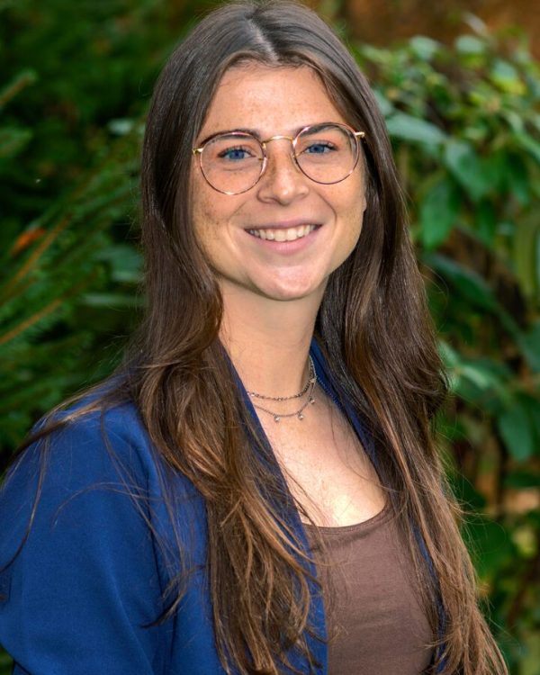 A woman with glasses smiling for the camera.